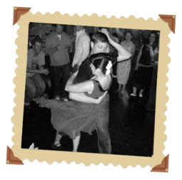 Black and white photo of a couple swing dancing. The man is dipping the woman. Framed in an ornate brown frame.